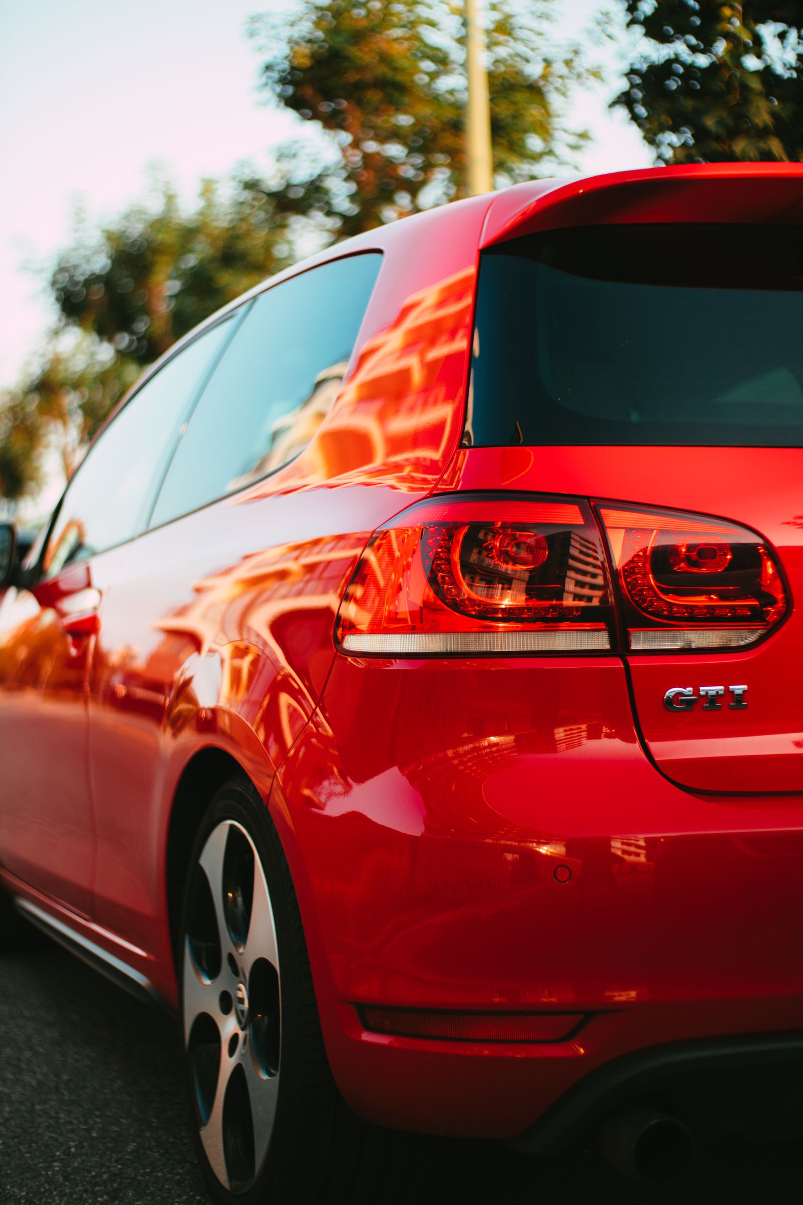 Close-up rear three-quarter shot of a red Volkswagen Golf GTI with visible GTI badge and taillight detail